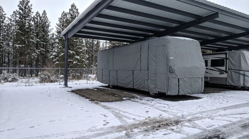 A motorhome under a winter cover at the storage lot