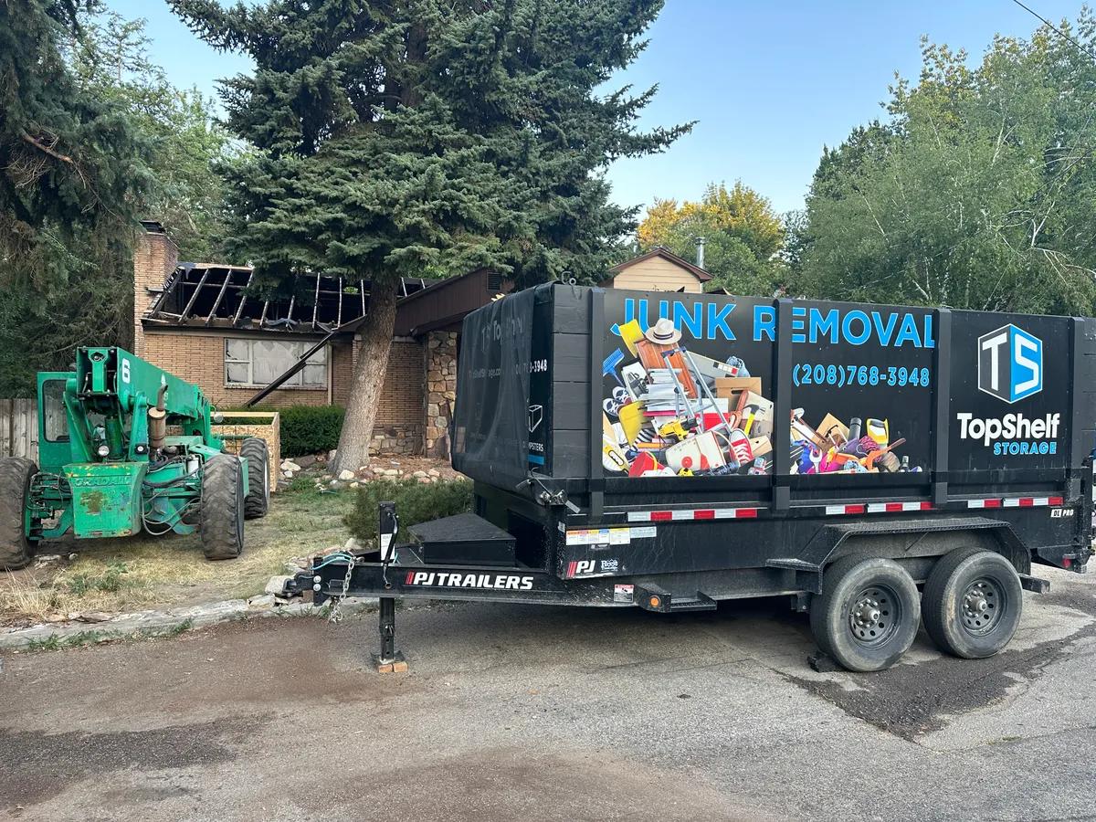 Top Shelf trailer and heavy equipment at a house demolition site in Boise, Idaho