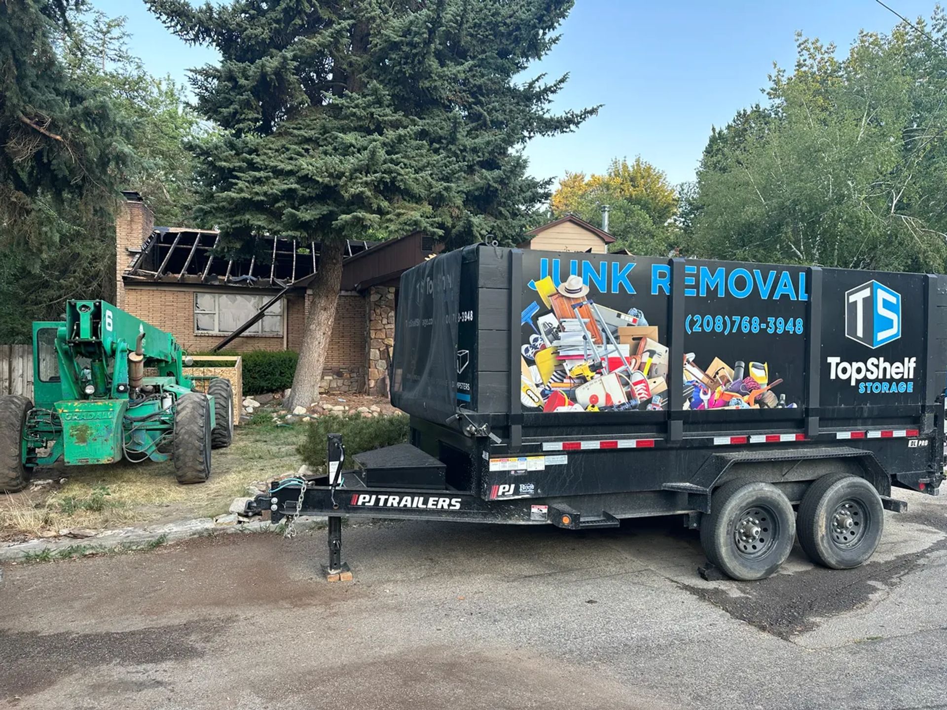 Top Shelf trailer and heavy equipment at a house demolition site in Boise, Idaho