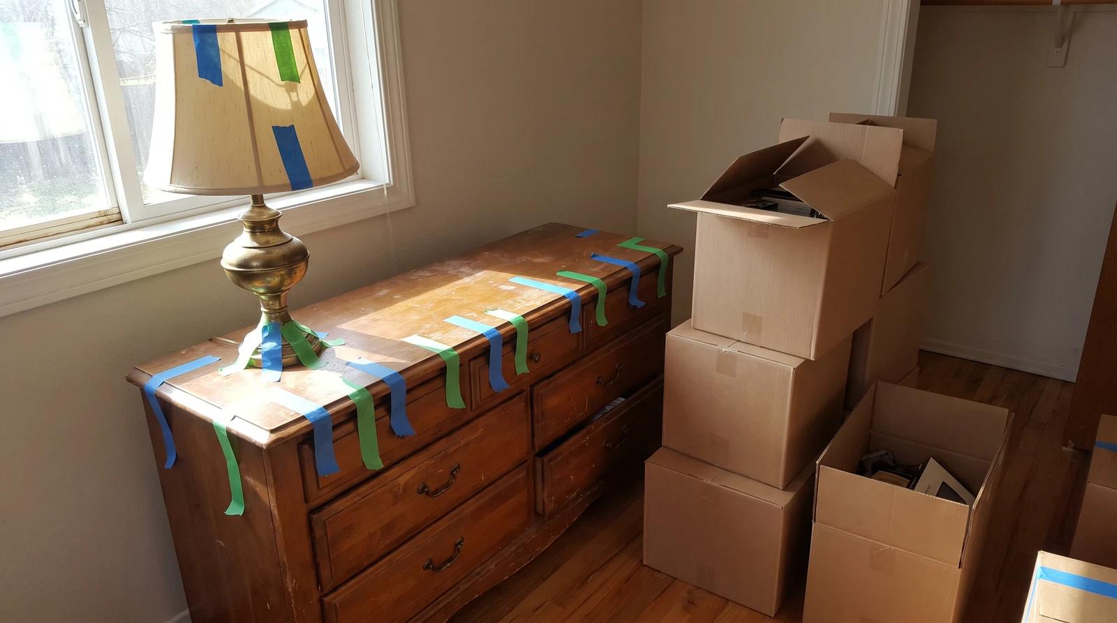 Wooden dresser and lamp tagged with colored painter's tape for heirs before a probate estate cleanout in Star, Idaho