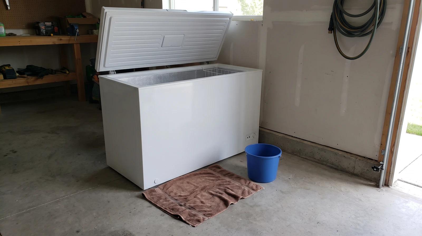 Unplugged white chest freezer with the lid open in a clean garage in Emmett, Idaho, ready for junk removal