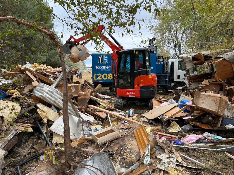 Excavator loading sorted demolition debris for recycling near Boise Idaho
