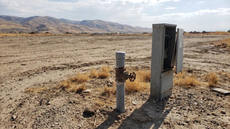 Capped water line and disconnected power pedestal on an empty mobile home lot in Boise, Idaho, after utility shutoffs and removal