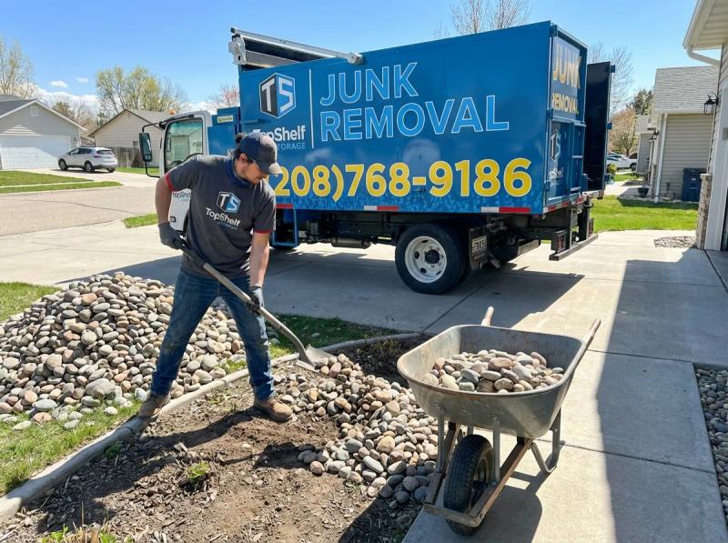 Top Shelf crew member loading rocks into the junk removal truck in Garden City Idaho