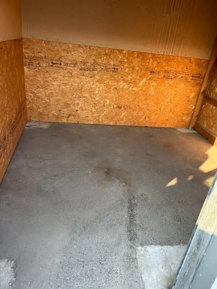 An emptied storage unit with the floor cleared after a cleanout
