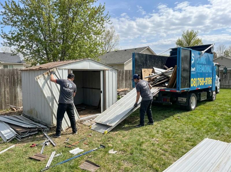 Top Shelf junk removal team loading demolished shed materials into the branded truck in Garden City Idaho