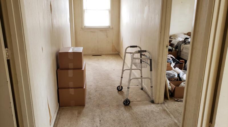 Cleared hallway with a walker by the bedroom door after a hoarding cleanup in a Boise, Idaho home