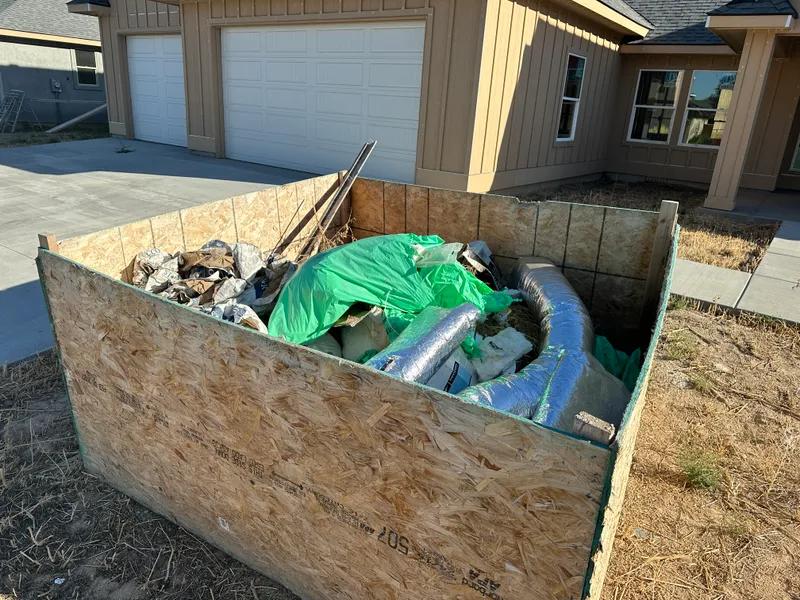 Dumpster loaded with plywood and insulation debris during construction cleanup