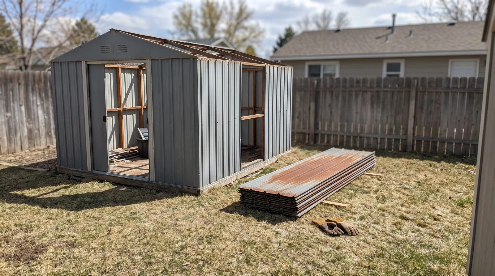 Rusted metal storage shed partly taken apart in a backyard in Meridian, Idaho, with roof panels stacked on the grass