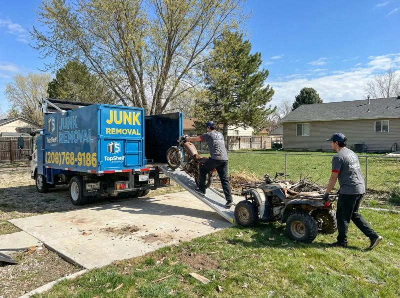 Top Shelf crew member loading boat trailer and motorsport equipment into the junk removal truck in Nampa Idaho