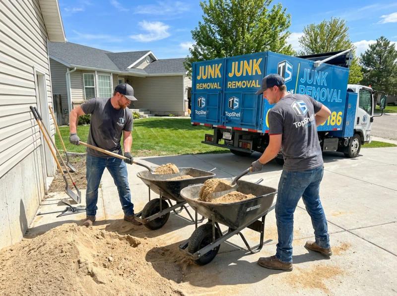 Top Shelf junk removal team hauling sand to the branded truck in Boise Idaho