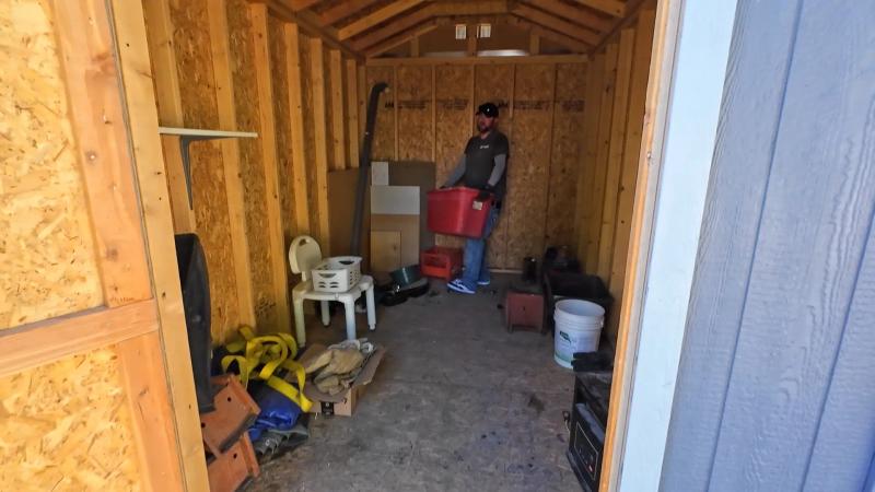Top Shelf crew member clearing bins boxes and tools from inside a shop during a cleanout in Kuna Idaho