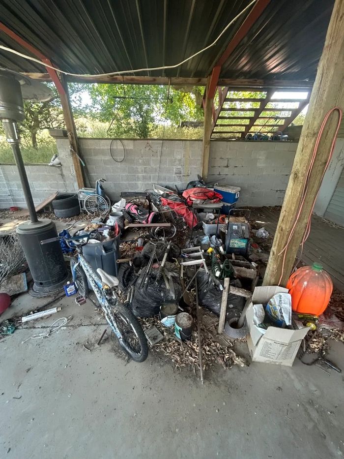 Before: carport packed with junk, ahead of a Man of Steel cleanout