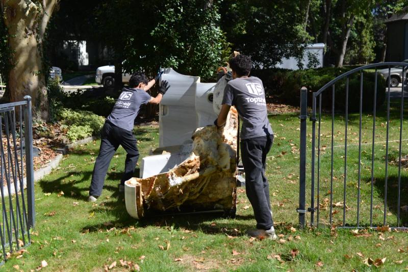 Top Shelf crew carrying a heavy hot tub during a removal job in Nampa Idaho