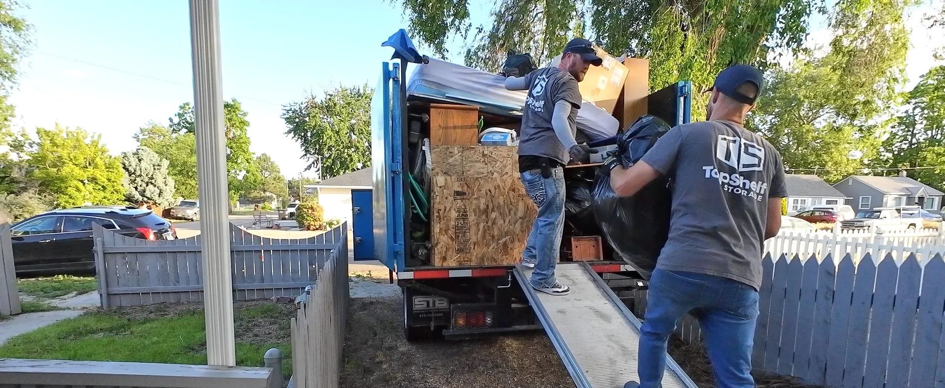 Top Shelf crew loading items up the truck ramp during a cleanout