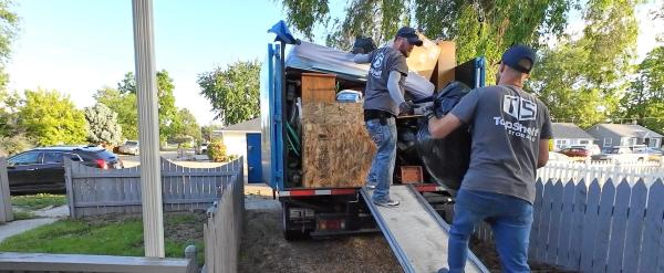 Top Shelf crew loading items up the truck ramp during a cleanout