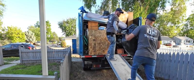 Top Shelf crew loading items up the truck ramp during a cleanout in Boise Idaho