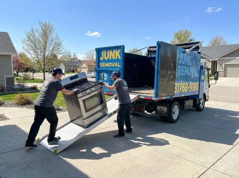 Top Shelf junk removal team hauling oven to the branded truck in Emmett Idaho