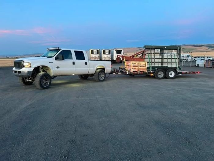 The Highway Desperado Hauling pickup and trailer parked on a gravel lot at dusk