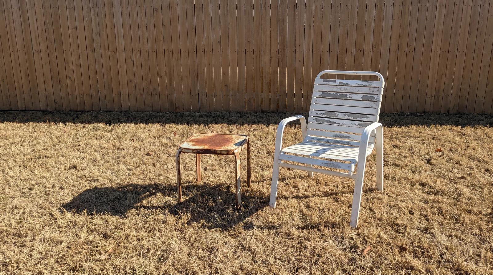 Weathered patio chair and rusted side table waiting for furniture removal in a Kuna, Idaho backyard
