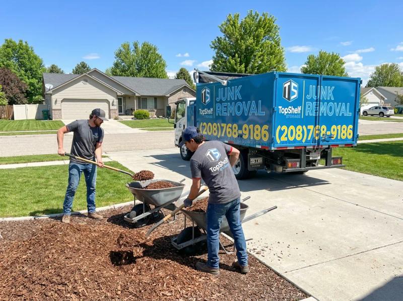 Top Shelf junk removal team hauling wood chips to the branded truck in Caldwell Idaho