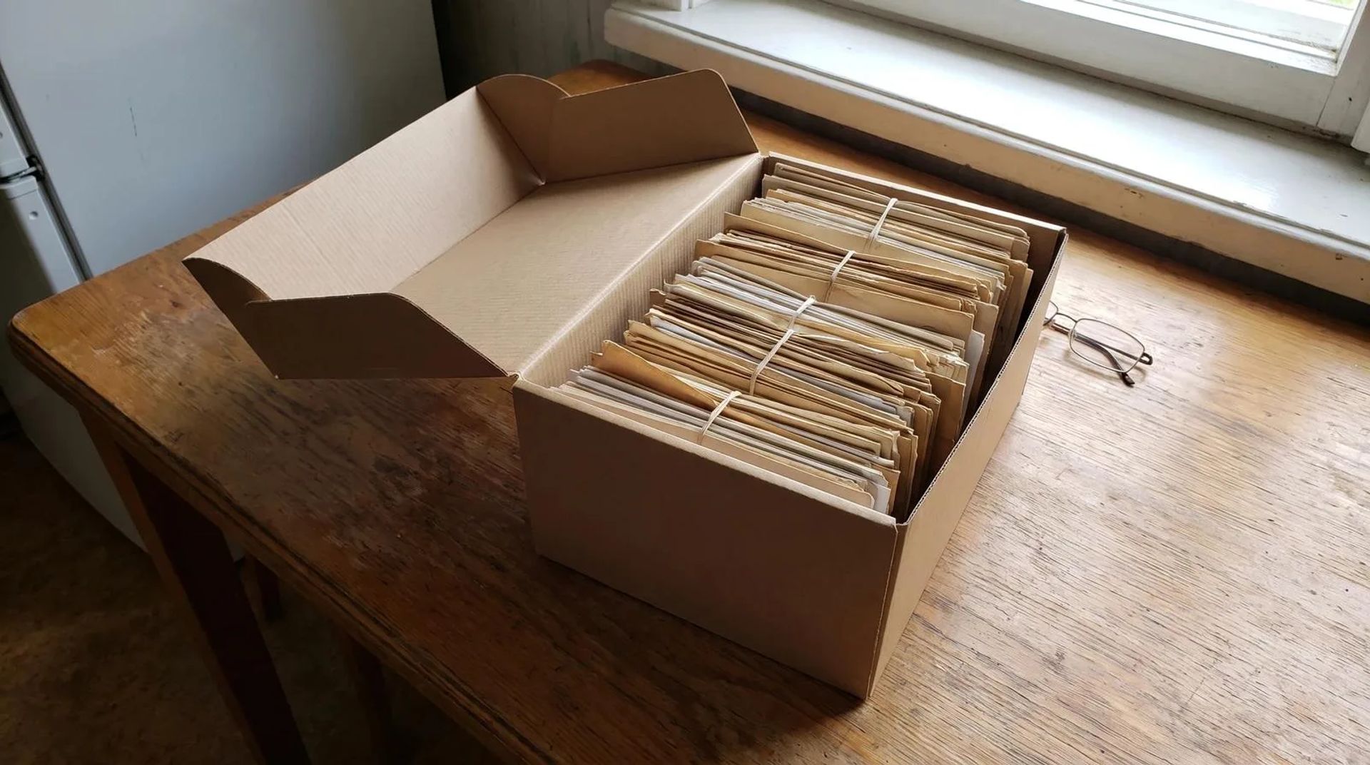 Box of old family photos and letters on a kitchen table during an estate cleanout in Boise, Idaho