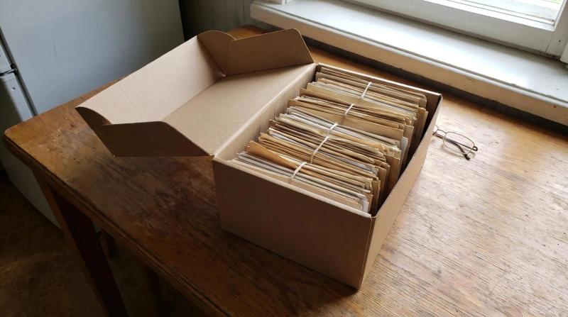 Box of old family photos and letters on a kitchen table during an estate cleanout in Boise, Idaho
