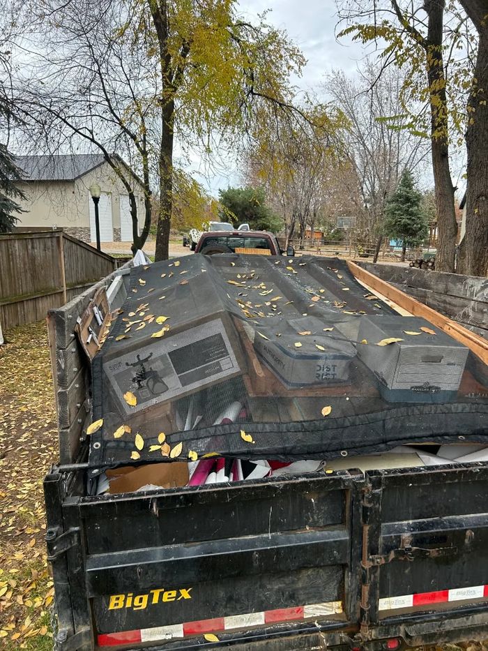 Tarped truck load of junk in autumn leaves