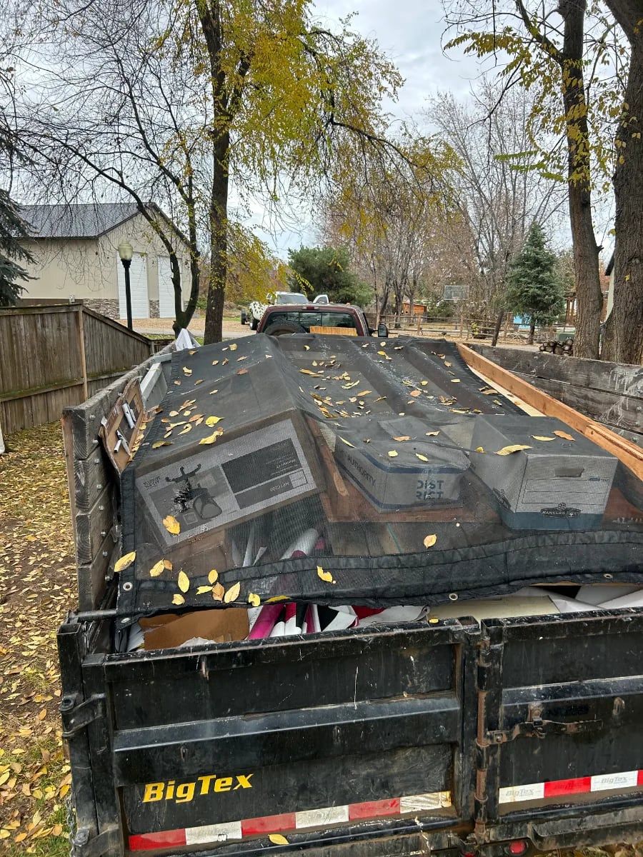 Tarped truck load of junk in autumn leaves