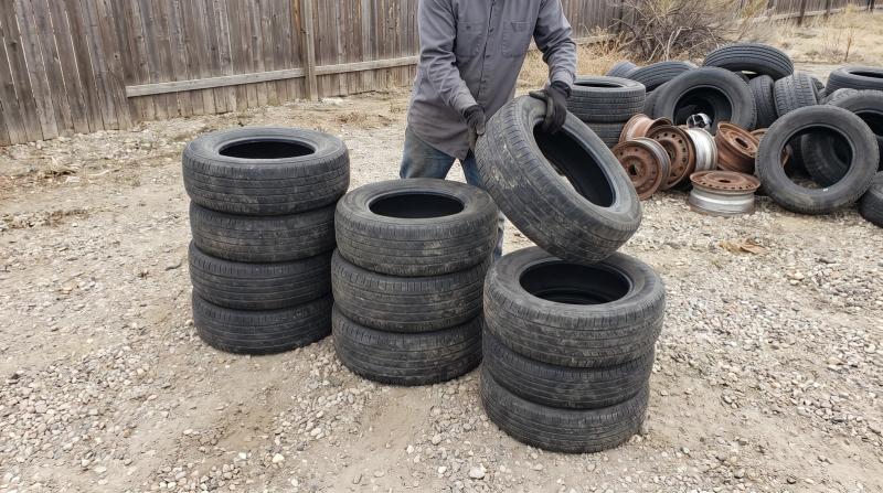 Used tires sorted by size into three stacks on a gravel lot in Kuna, Idaho, ready for commercial tire removal
