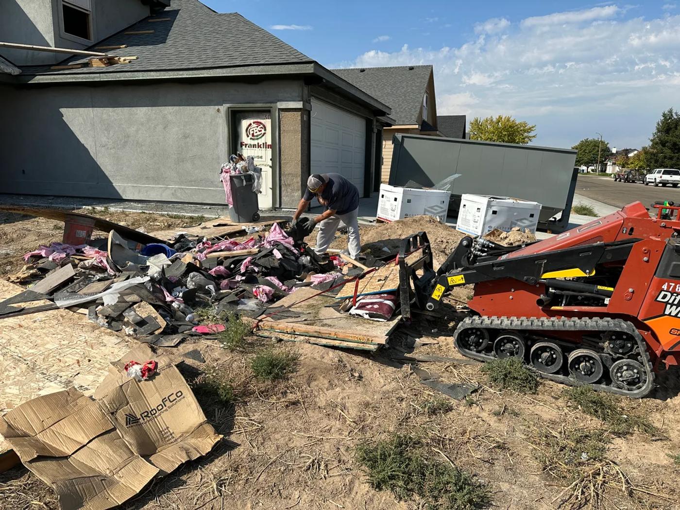 Skid steer cleaning up construction debris at a job site in the Boise Idaho area