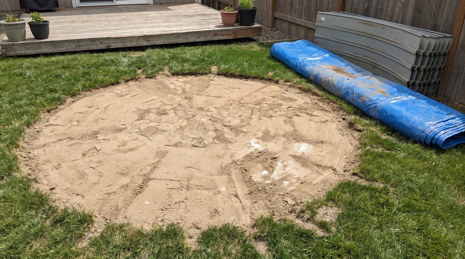 Sand base, rolled pool liner and stacked wall panels left after above ground pool removal in a Kuna, Idaho backyard