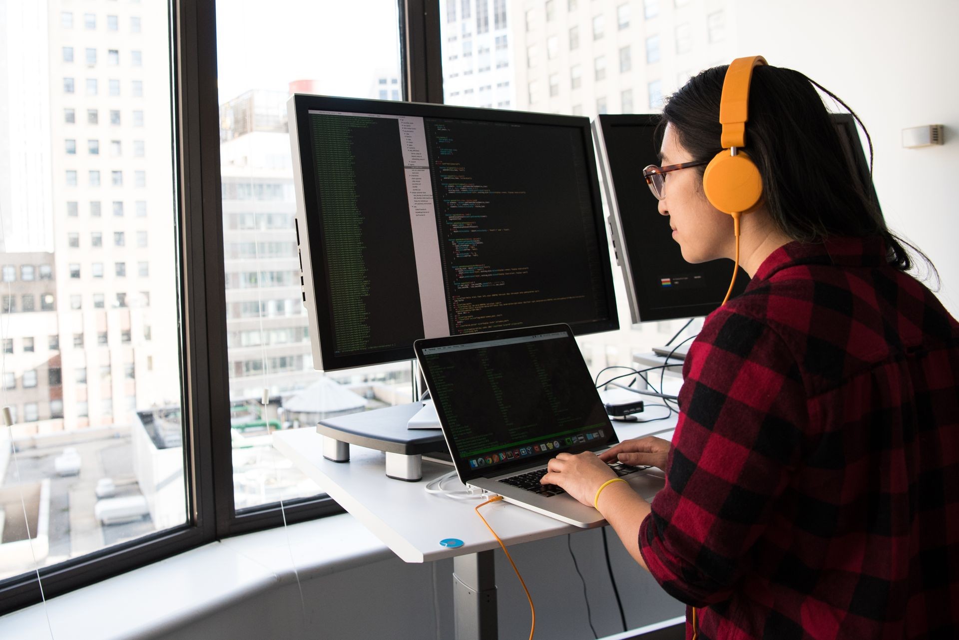 Developer working on a laptop with analytics dashboards