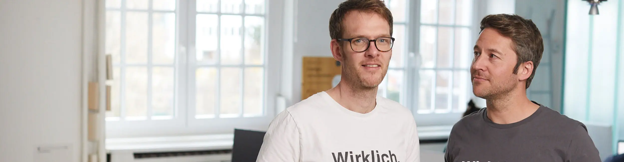 Simon und Florian stehen im Büro