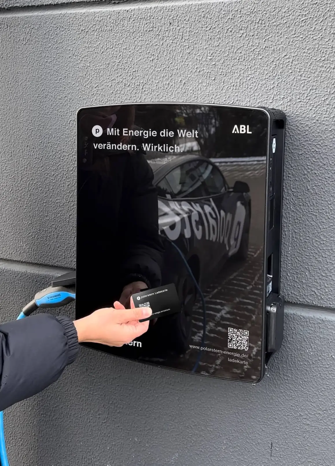 Hand mit Ladekarte vor Polarstern-Wallbox