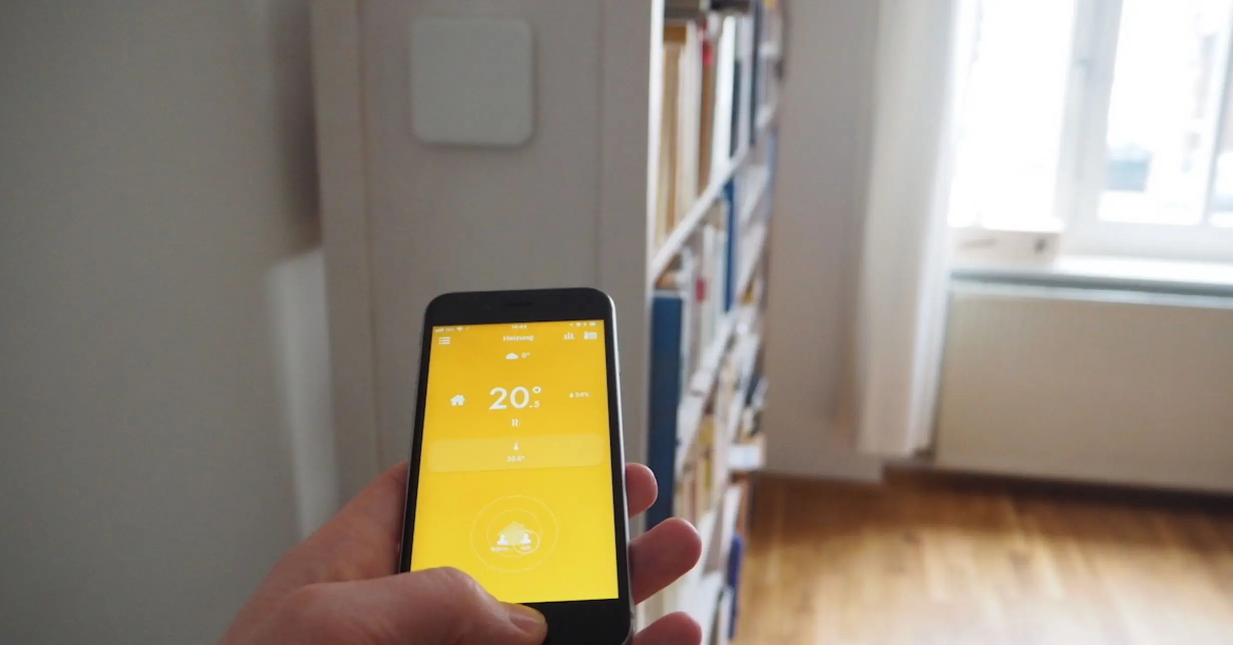 Smartphone mit Smart Home App im Wohnzimmer