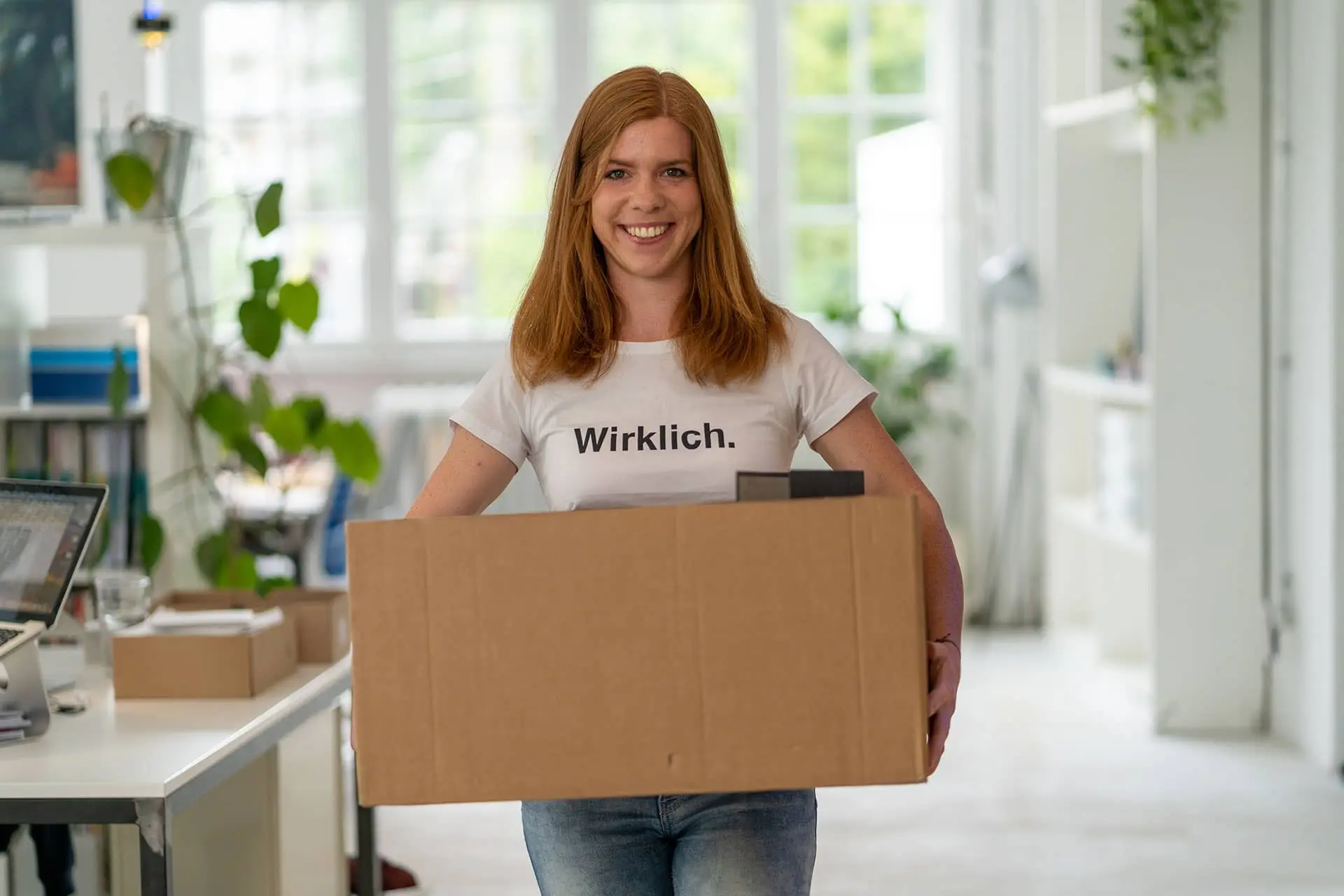 Frau hält Umzugskarton in den Händen