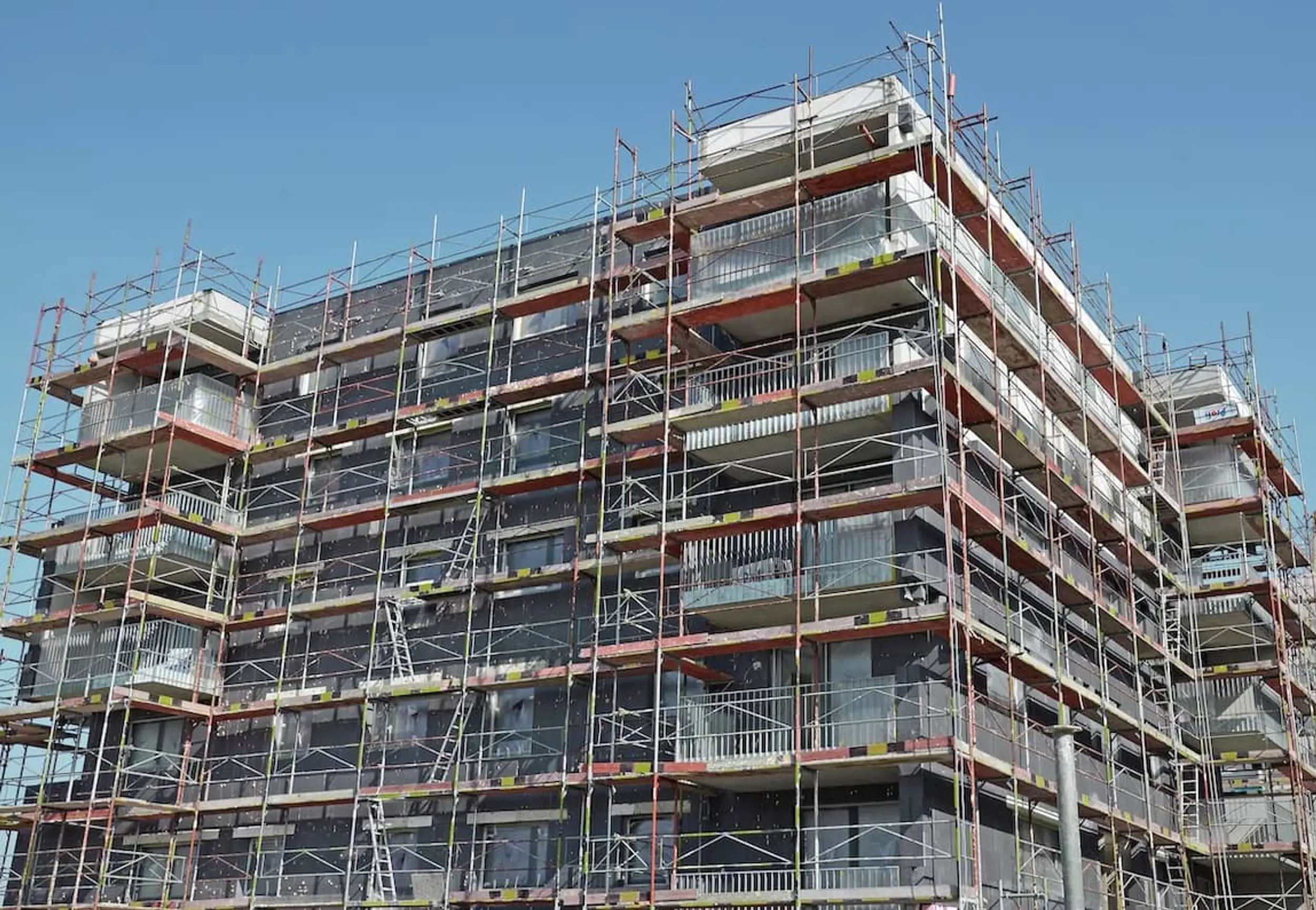 Ein mehrstöckiges Gebäude im Bau, vollständig mit Gerüsten bedeckt.