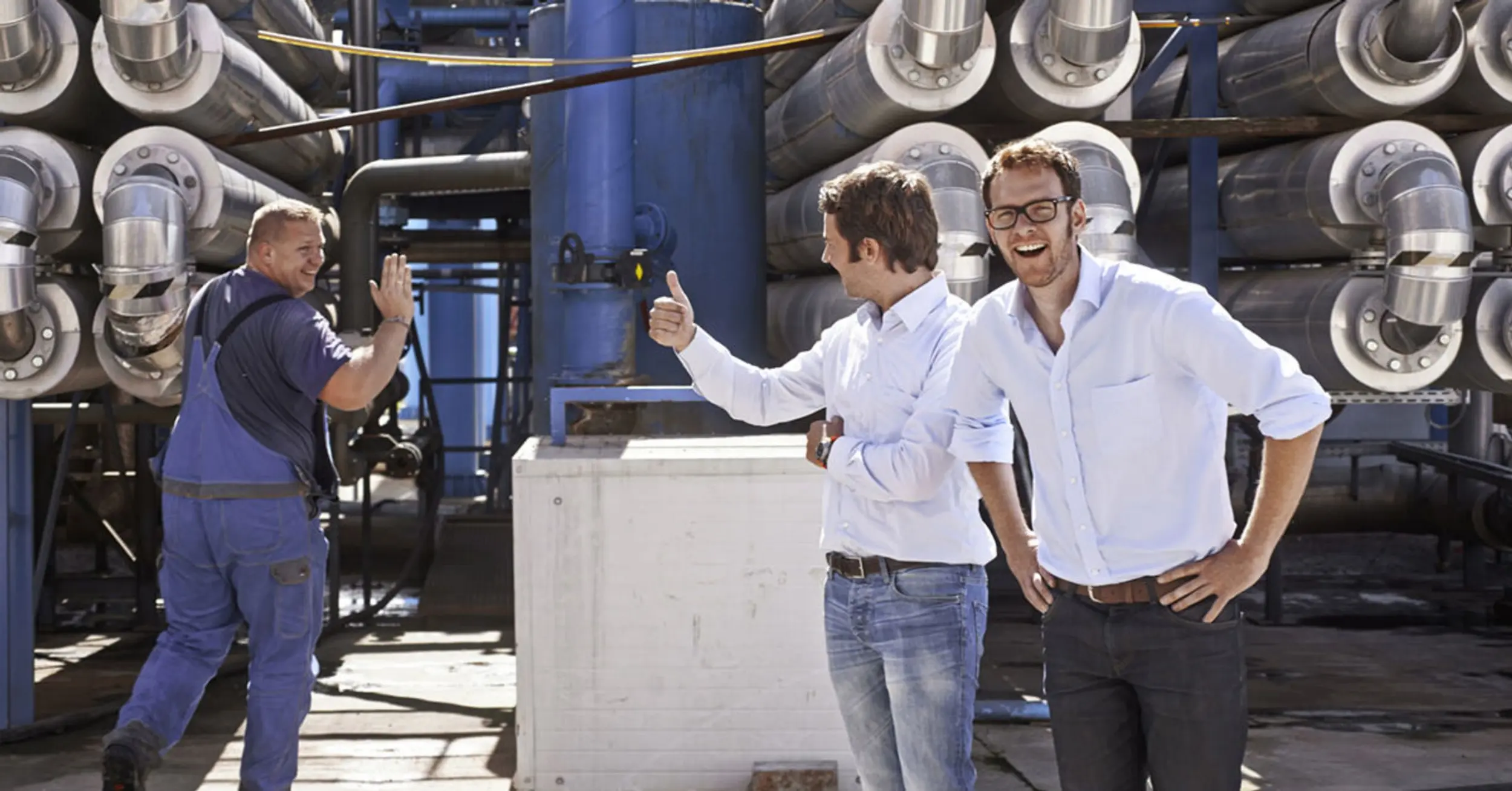 Simon und Florian vor Biogasanlage mit Mitarbeiter