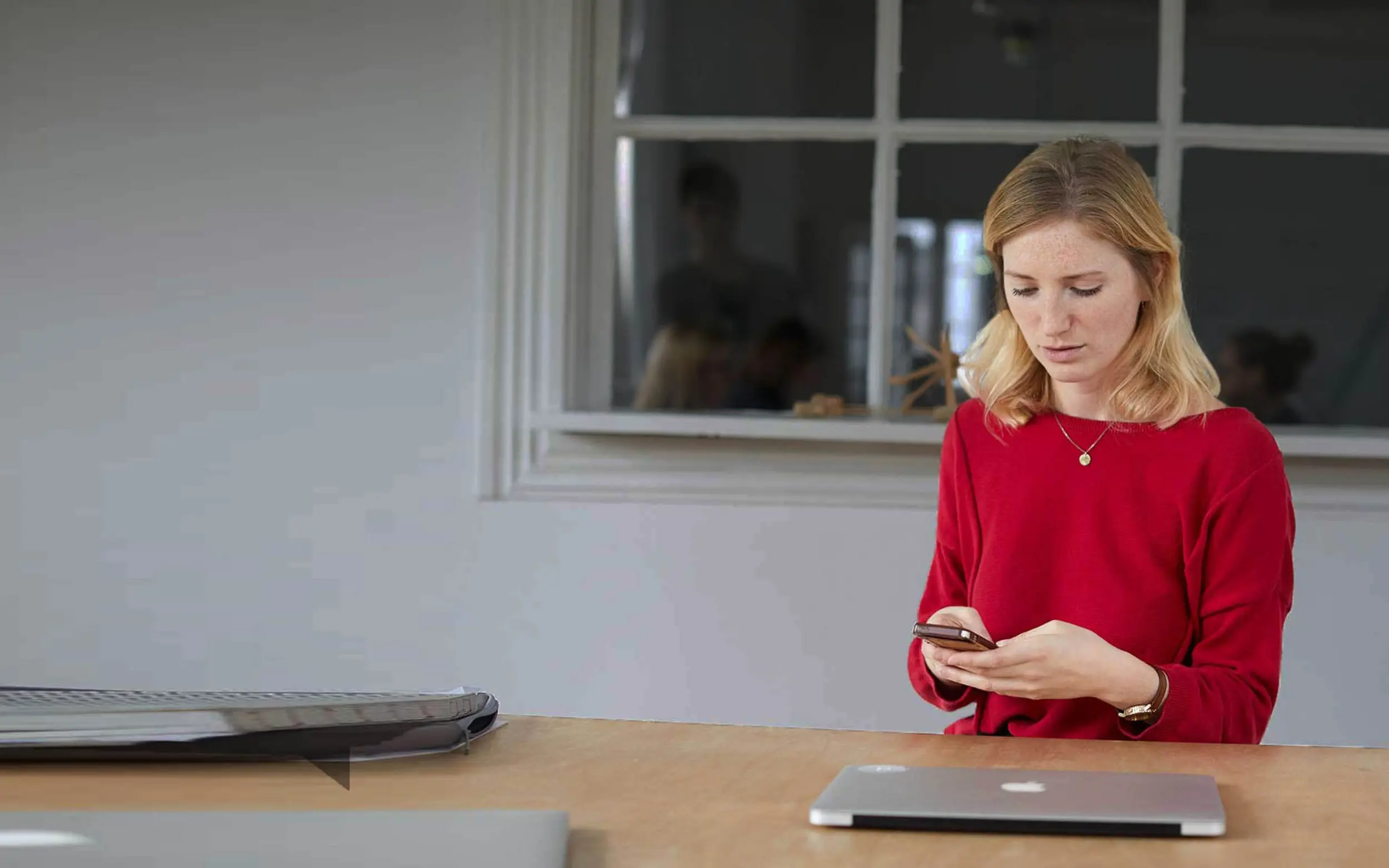 Frau schreibt Bewertung am Handy