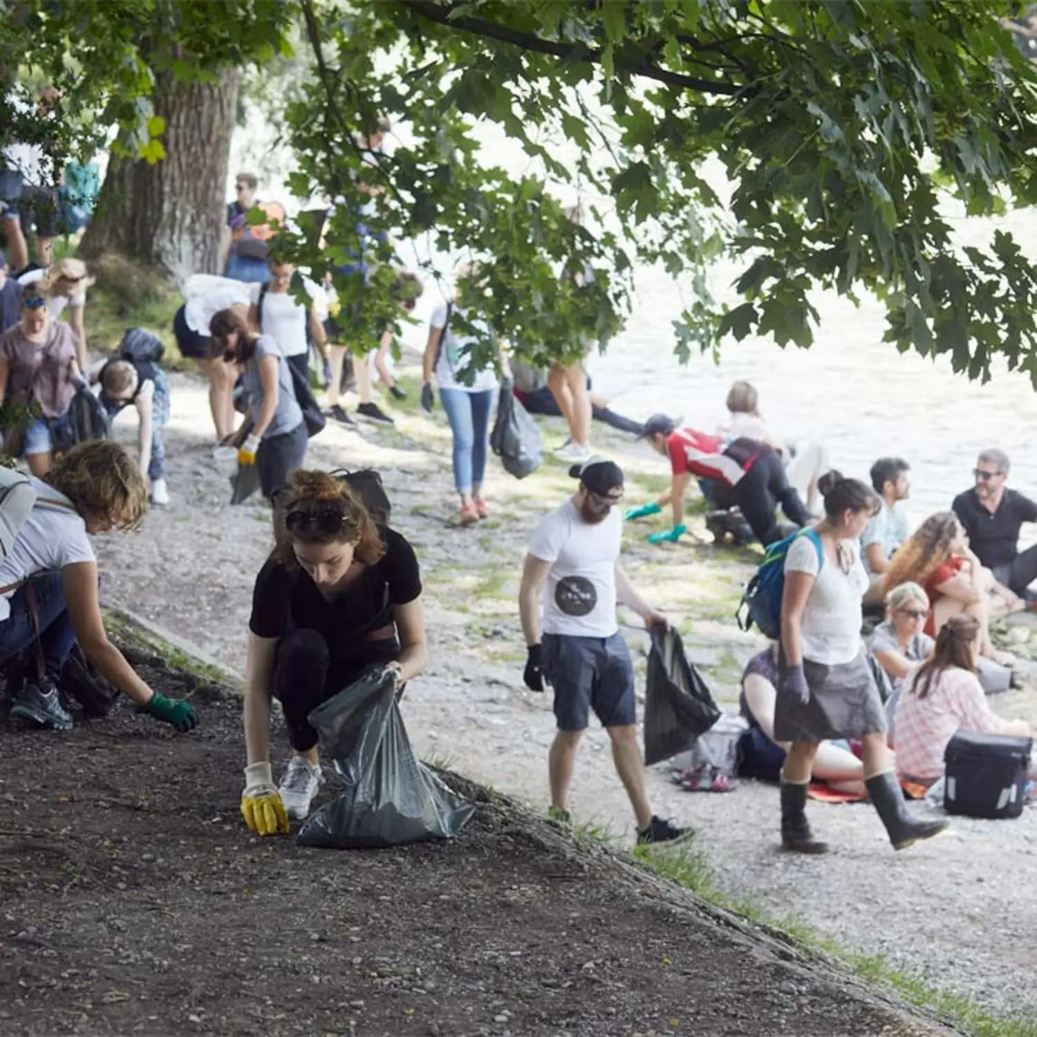 Menschen räumen Müll an der Isar auf