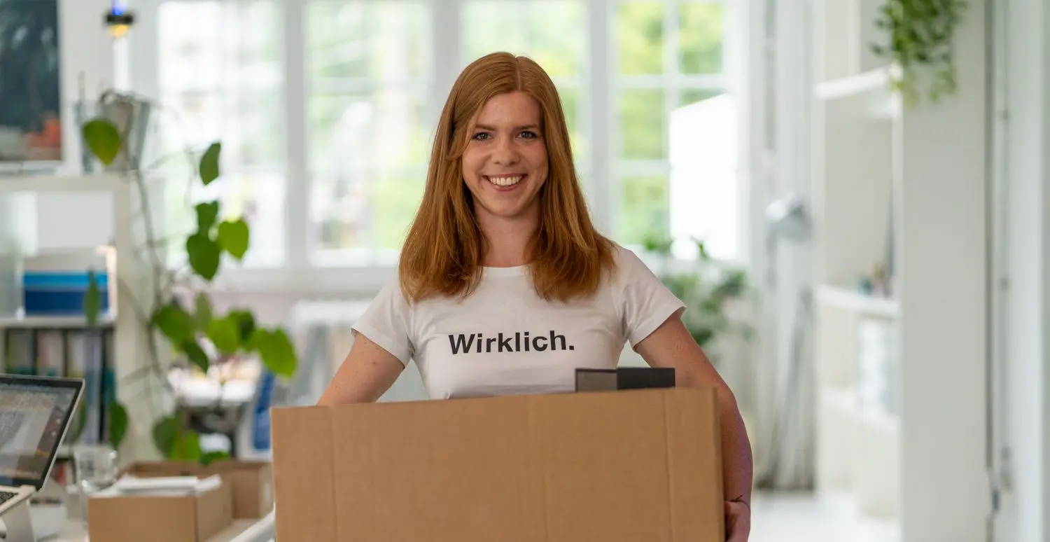 Frau hält Umzugskarton in den Händen