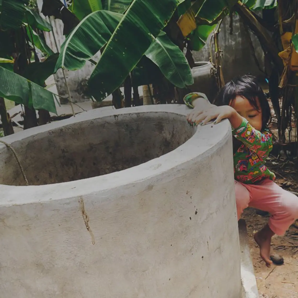 Kind hinter Ökogasanlage
