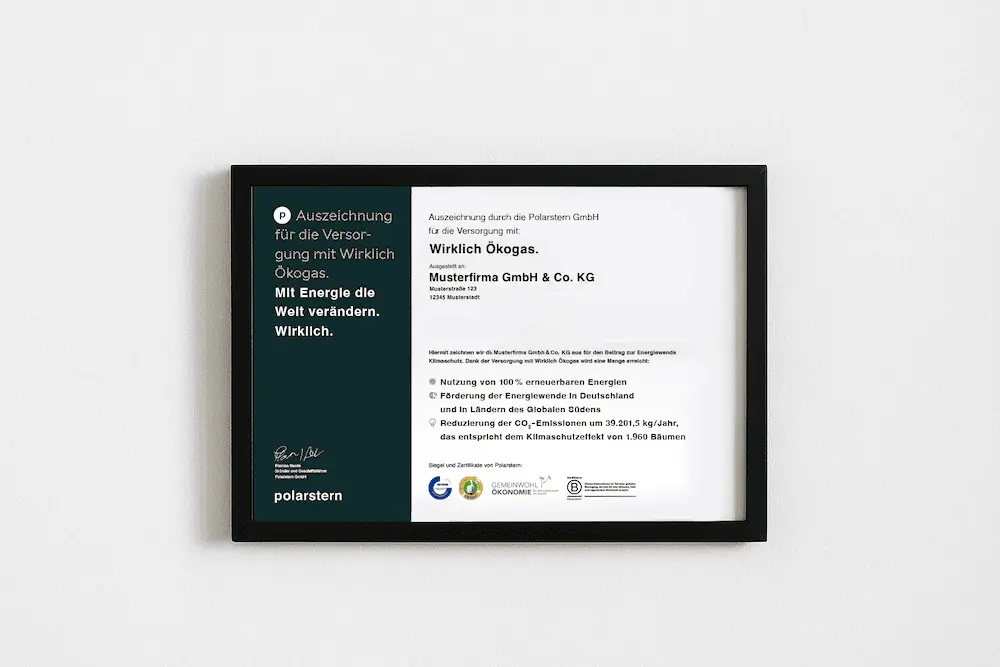 Ein gerahmtes Zertifikat liegt auf einem Holztisch vor einer weißen Ziegelwand.