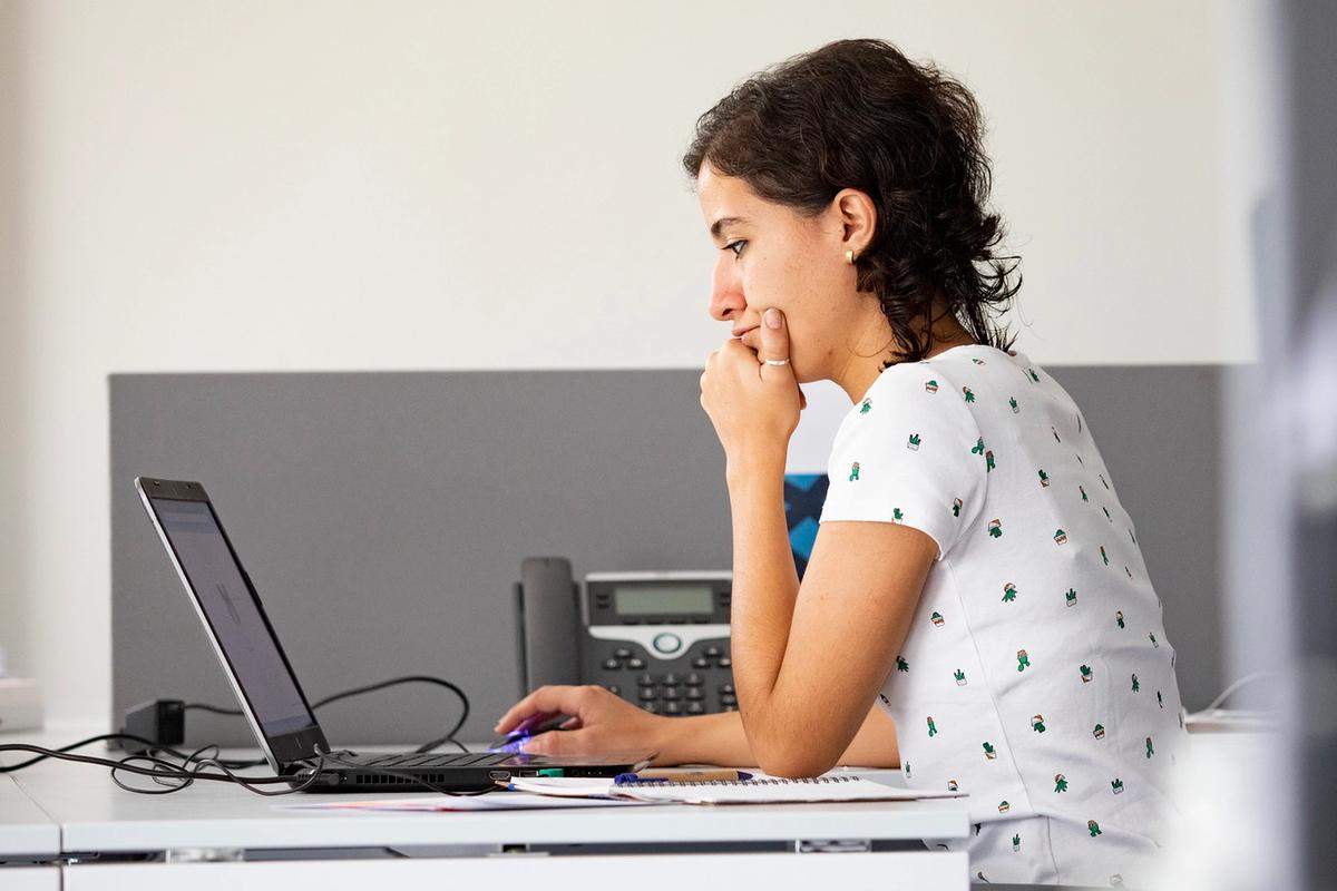 A woman works with a laptop in front of her