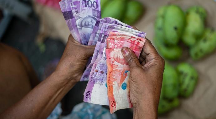 A fruit vendor counts her bills in Quiapo, Manila, Philippines, on March 10, 2021.