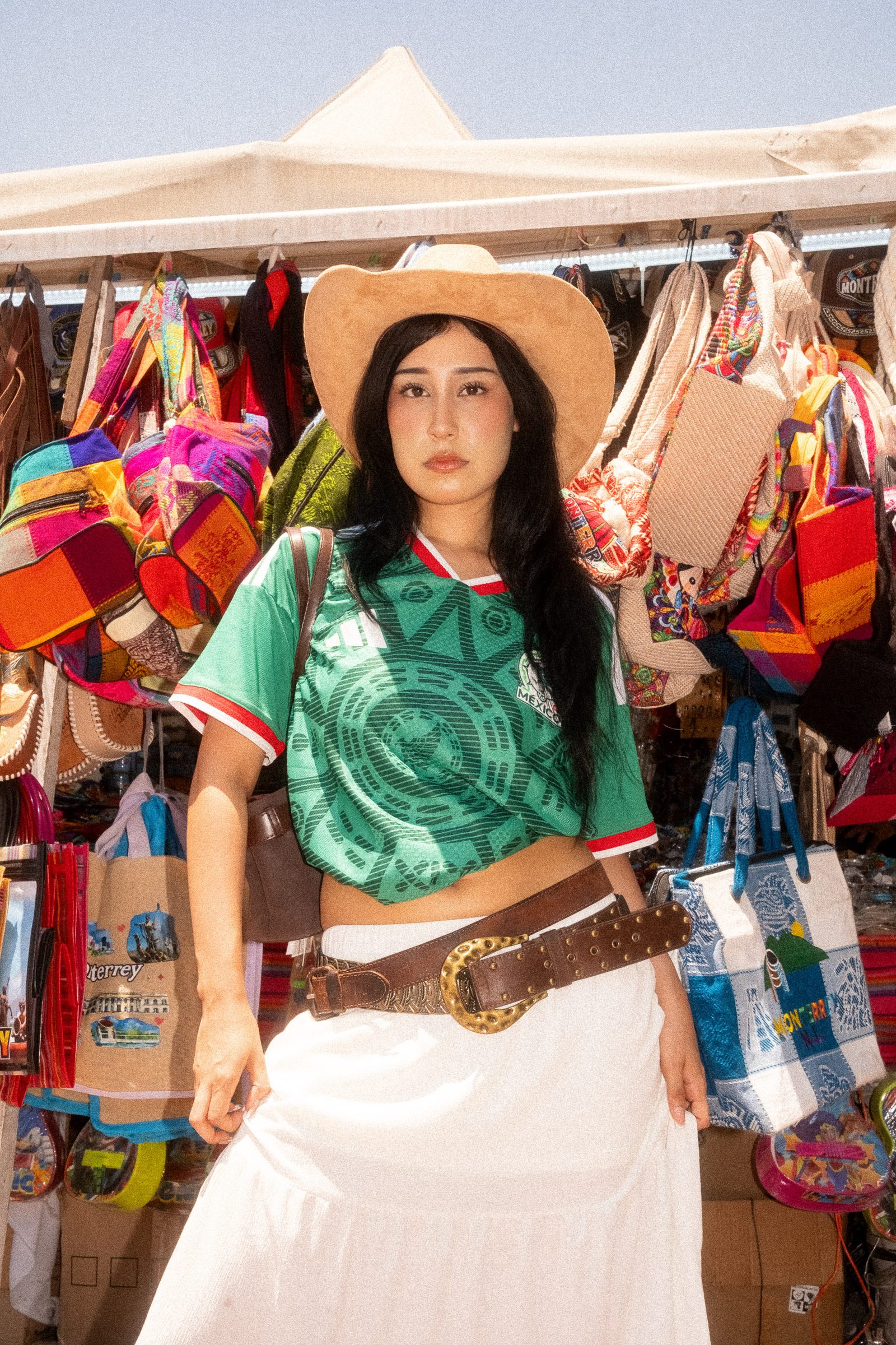 Liz con sombrero y el jersey de la Selección Mexicana en un mercado de ropa mexicana