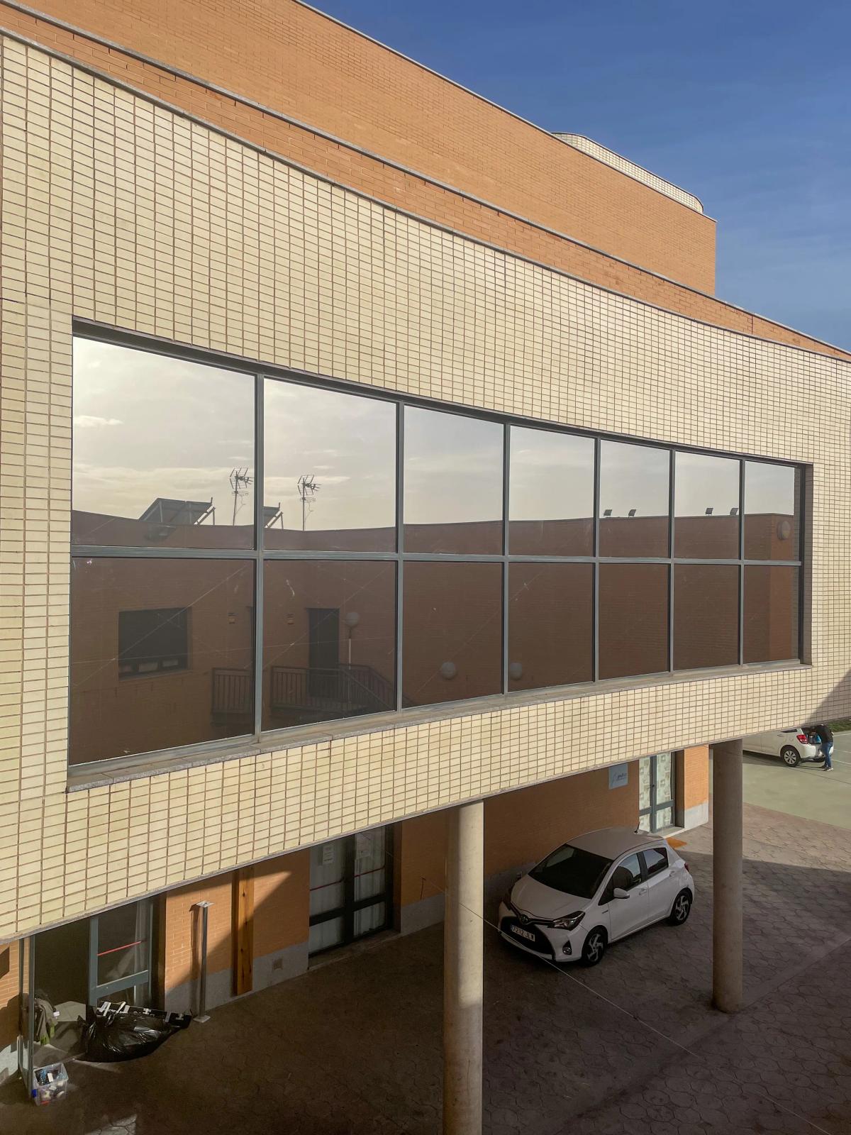 Fachada de edificio moderno con acristalamientos tratados con láminas solares de aboutwrap studio.