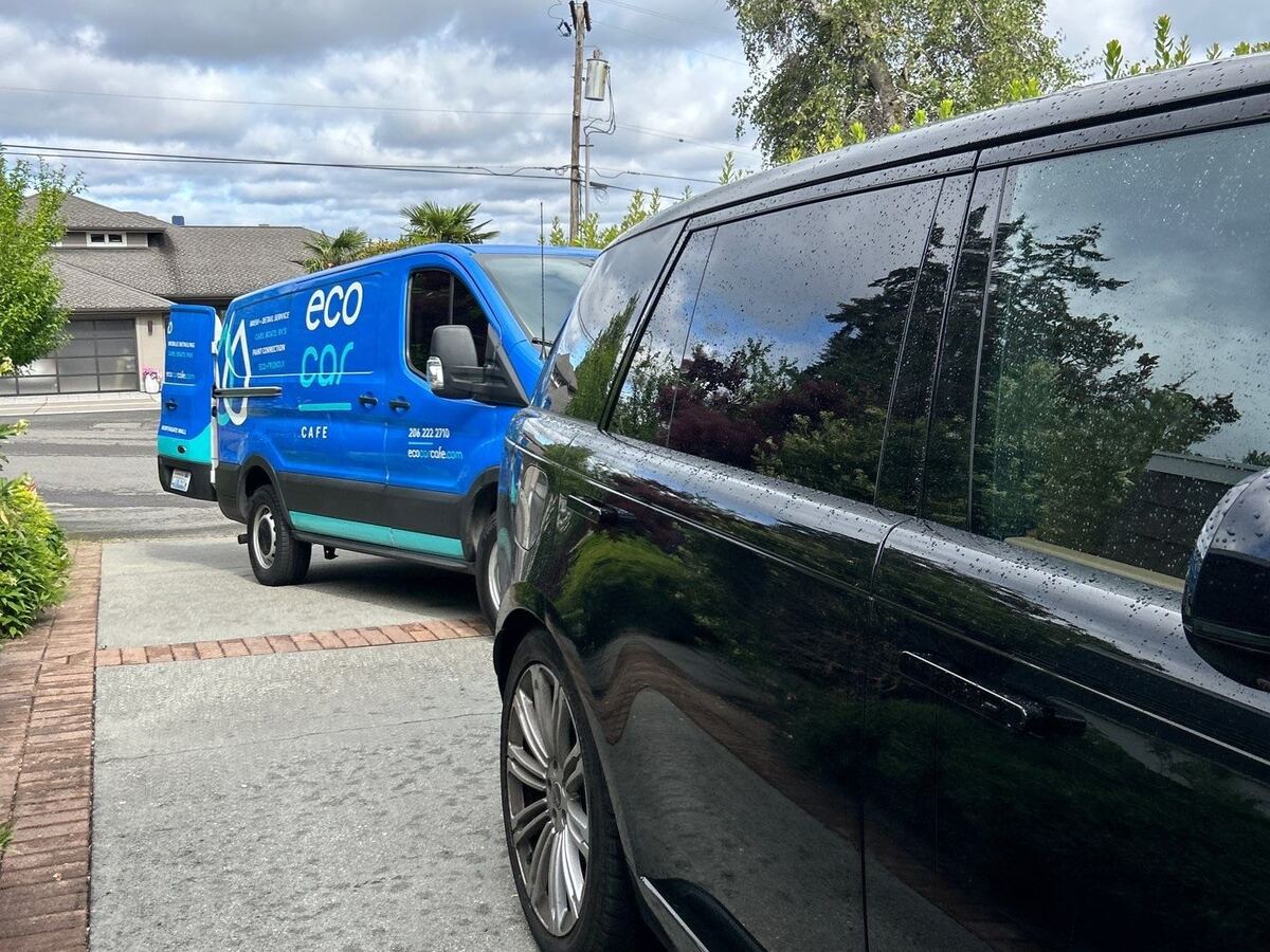 Mobile detailing van parked behind a black SUV on a residential street
