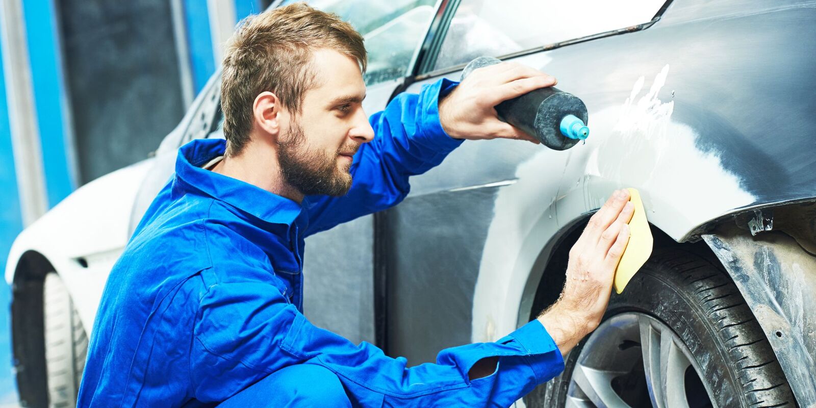 Man polishing a gray car fender